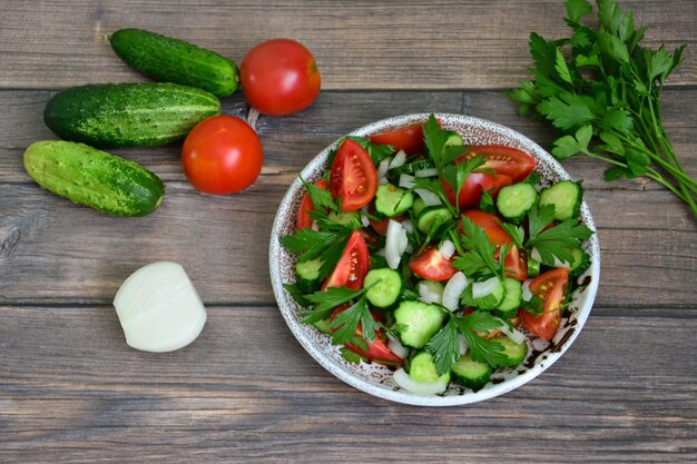 Tuin groente salade met tomaat, komkommer, ui en peterselie geïsoleerd, close-up