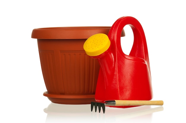 Tuin plastic pot plastic rode gieter en hark op een witte achtergrond