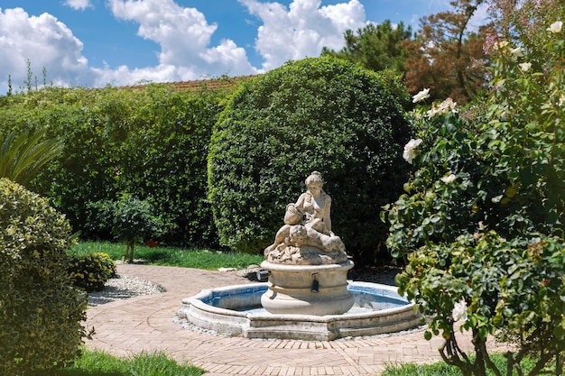 Tuinbeeld een gedroogde verwaarloosde fontein met een mooie vrouw en kind op de paden