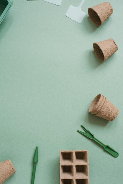 Tuinbouwconcept Het planten van zaailingen van groente- of bloemgewassen in het huis Torfcassettes voor zaailingtuinen Tuinpotten gereedschappen op een groene achtergrond Platte copierruimte