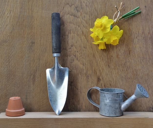 Tuingereedschap gerangschikt op een houten tafel met narcissen