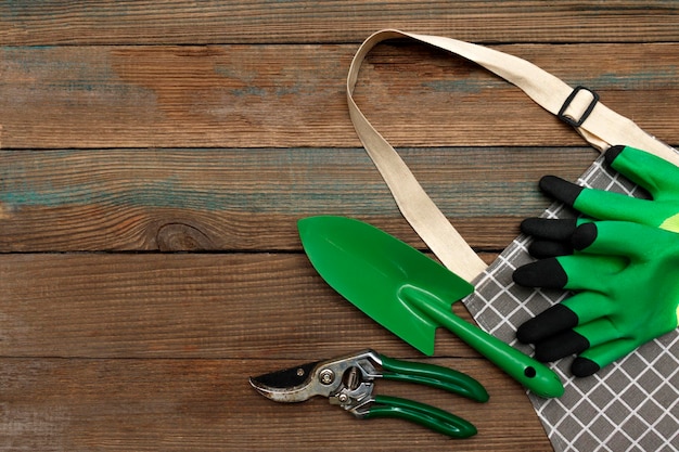 Tuingereedschap handschoenen snoeischaar spatel en tuinman schort op een houten rustieke achtergrond bovenaanzicht Tuin landschapsarchitectuur en hobby concept