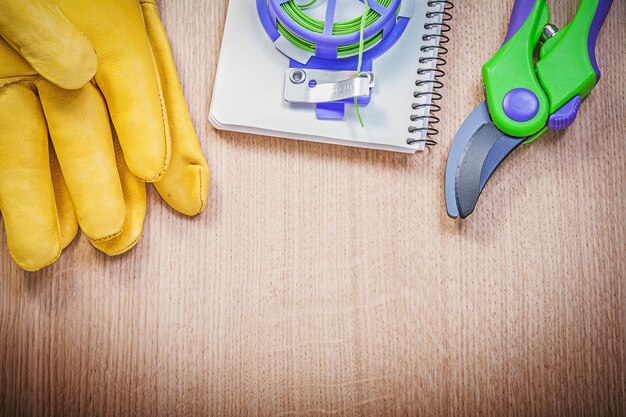 Tuinieren beschermende handschoenen snoeischaar tuin stropdas draad notitieblok op houten plank landbouw concept