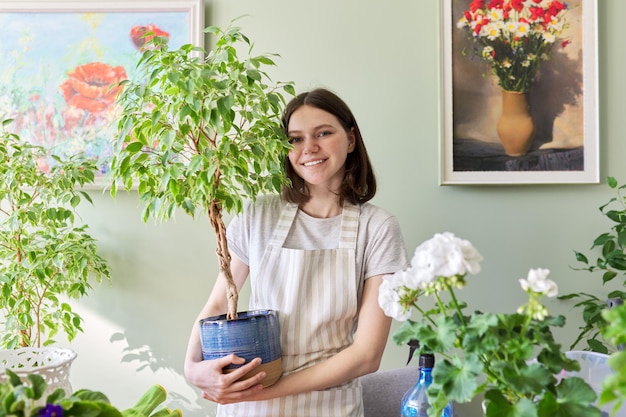 Tuinieren van appartement met kamerplanten, nieuwe trend stedelijke jungle, tienermeisje dat zorgt voor potplant, Benjamin's ficusboom