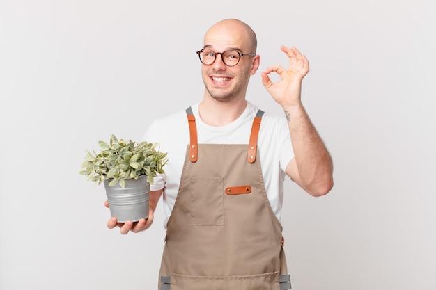 Tuinman die zich gelukkig, ontspannen en tevreden voelt, goedkeuring toont met een goed gebaar, glimlachend