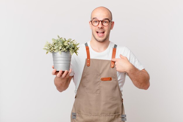 Tuinman die zich gelukkig, verrast en trots voelt, wijzend naar zichzelf met een opgewonden, verbaasde blik