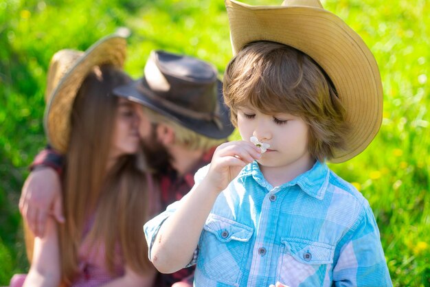 Tuinman familie op picknick buiten. zomer ouder met kind in tuin of park. ouderschap samen vrije tijd concept. vife echtgenoot kus.