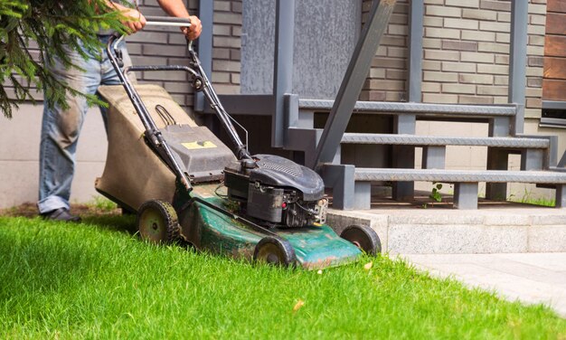 Tuinman maait het groene gazon in de tuin.