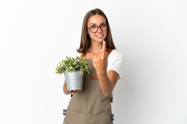 Tuinman meisje met een plant geïsoleerd doen komend gebaar