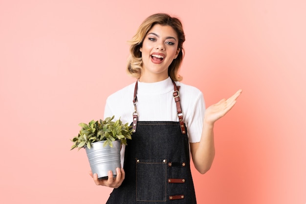 tuinman meisje met een plant met verbazing gezichtsuitdrukking