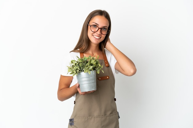 Tuinman meisje met een plant over geïsoleerde witte achtergrond lachen