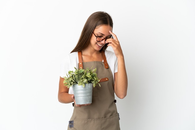 Tuinman meisje met een plant over geïsoleerde witte achtergrond lachen