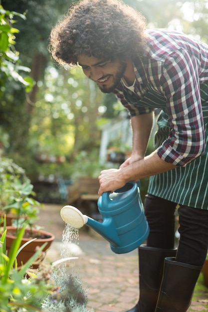 Tuinman planten buiten de kas water geven