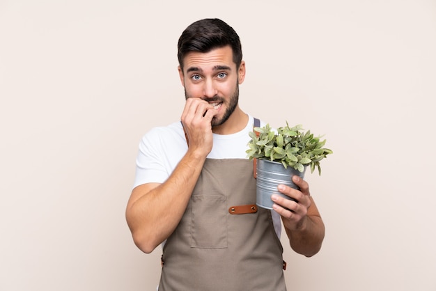 Tuinmanmens die een installatie over geïsoleerde muur houden