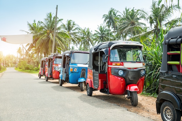 スリランカ、セイロンの旅行車の道のトゥクトゥクタクシー。セイロン熱帯林と伝統的な観光輸送