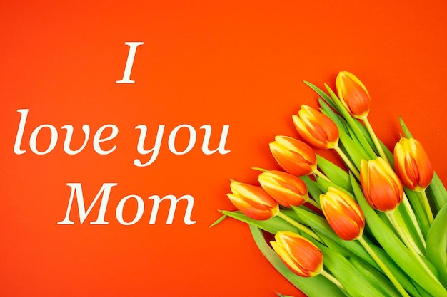 Tulips are yellowred on a red background and the text I LOVE YOU MOM in white letters