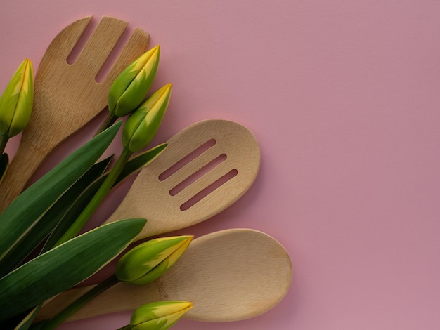Tulips flowers with kitchen tools on background with copy space