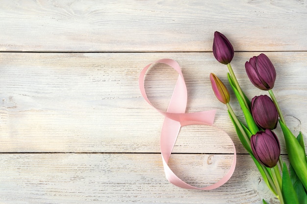 Tulips and the number eight from a ribbon on a light background. Top view with space to copy.