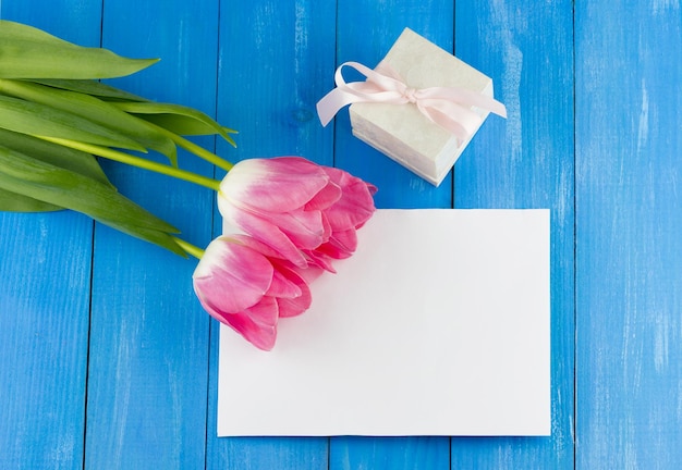 Tulips with sheet of paper and gift box