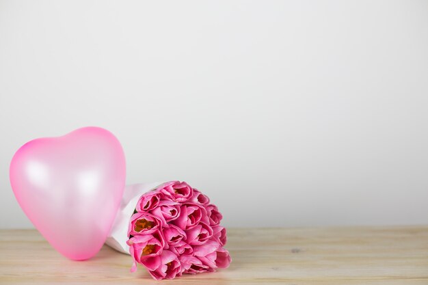 Tulpen en een hartvormige ballon op de tafel