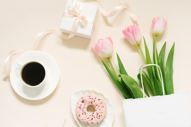 Tulpen geschenkdoos en koffie op een beige achtergrond Plat lag 8 maart Internationale Vrouwendag