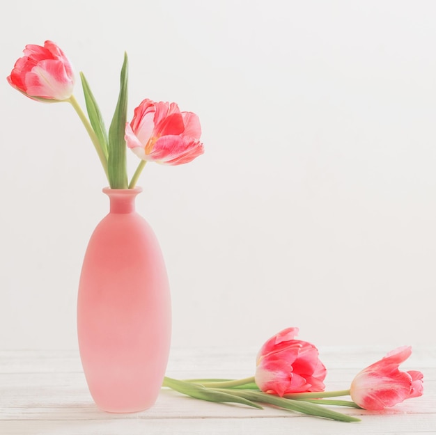 Tulpen in roze vaas op witte tafel