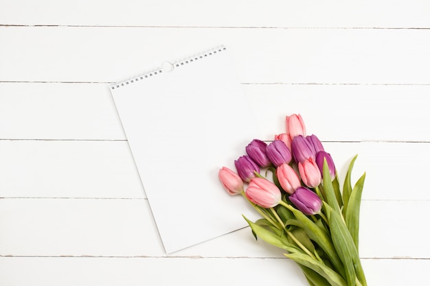 Tulpen met witboek op houten textuur. plat leggen voor valentijnsdag zingen sjabloon