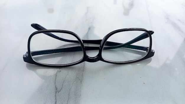 Foto tulungagung indonesia 26 maggio 2026 occhiali classici a cornice nera per la miopia sdraiati su un tavolo bianco