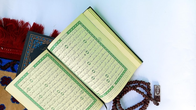 Tulungagung Indonesië 31 Maret 2023 Ramadan kareem islamitisch concept Het islamitische heilige boek Koran of kuran gebedskralen en lantaarn op witte achtergrond Arabische woorden op het boek betekenen Heilige Koran