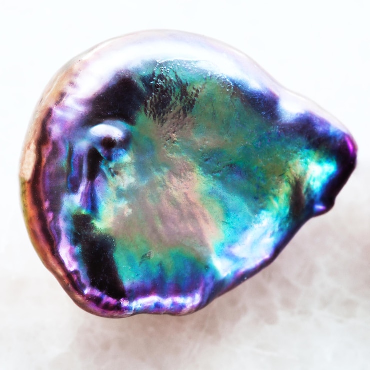 Photo tumbled abalone haliotis stone on white marble