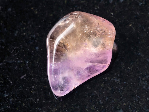 Tumbled Ametrine gemstone on dark background