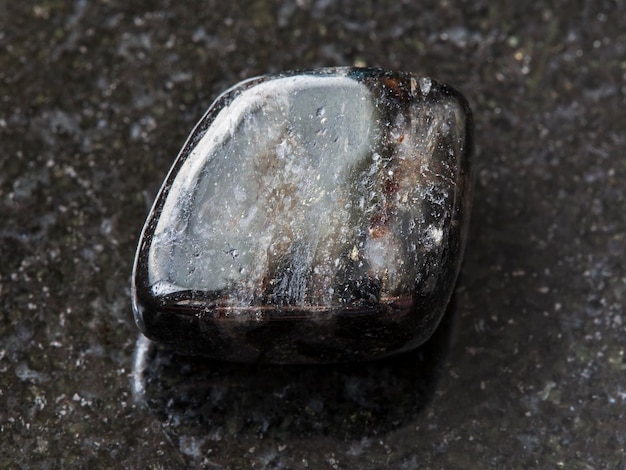 Photo tumbled anthophyllite gemstone on dark