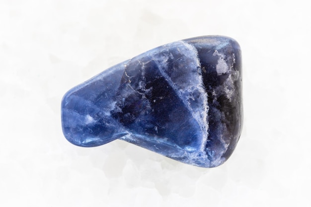 Tumbled Dumortierite gemstone on white marble