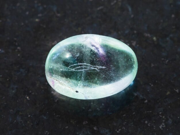 Tumbled fluorite gemstone on dark background