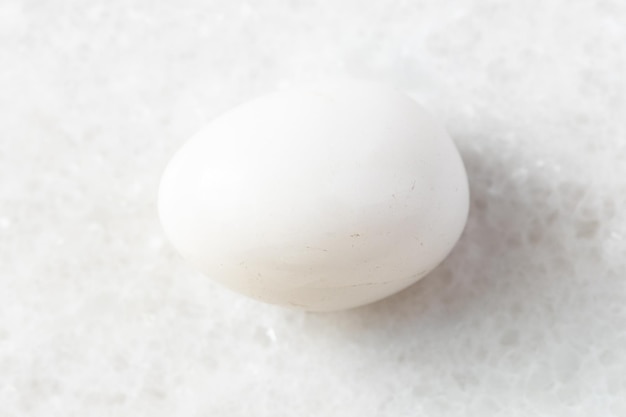 Tumbled Milky Quartz rock on white marble