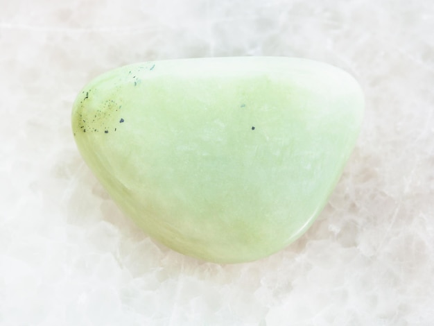 Tumbled Prasiolite gemstone on white marble