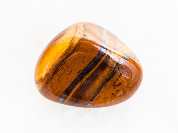 Tumbled tigers eye gem stone on white