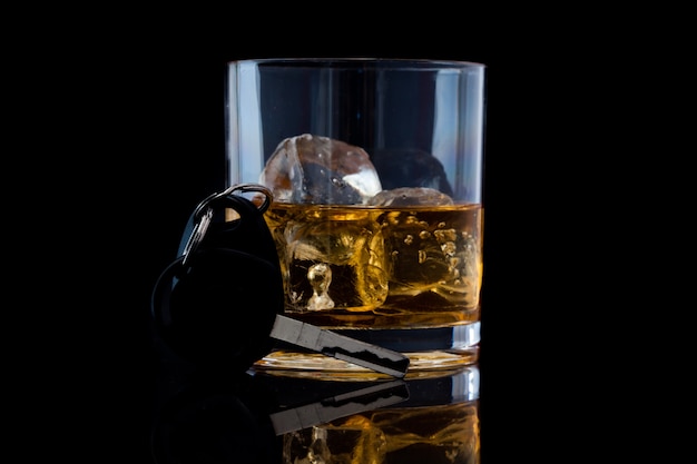 Tumbler glass with whiskey and a car key