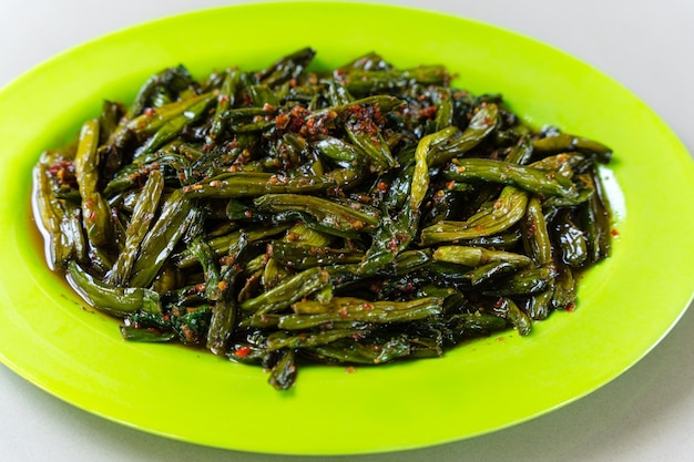 Tumis genjer or oseng genjer is Indonesian traditional food. Served on green plate