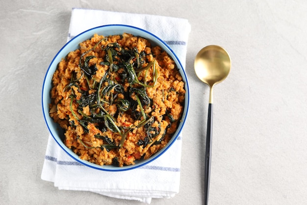 Tumis kangkung oncom or vegetable stir fried water spinach on a blue plate