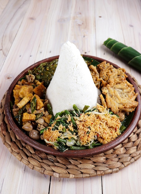 Tumpeng nasi jagung corn rice in a cone shape Nasi Tumpeng A festive Indonesian rice dish