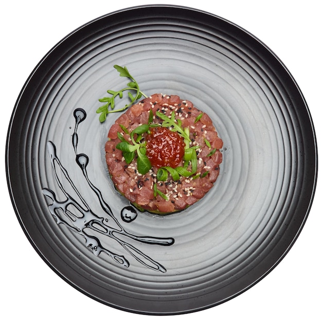 Photo tuna and avocado tartare on a dark ceramic plate