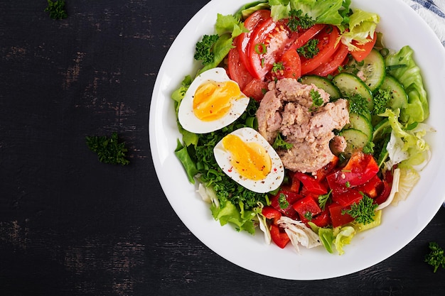 Tuna fish salad with lettuce tomatoes cucumber boiled egg and sweet pepper Healthy food French cuisine Top view copy space flat lay