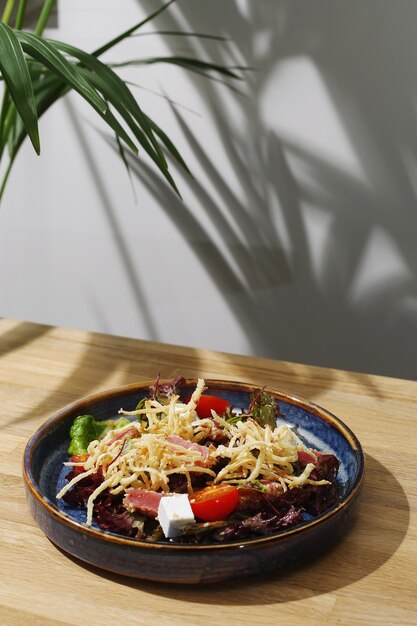 Tuna salad with feta and tomatoes closeup on wooden table.