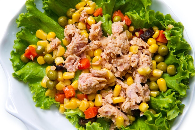 Foto insalata di tonno con mais su piatto di conchiglie bianche