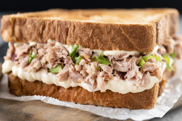 Tuna sandwich with mayo and vegetables on gray surface