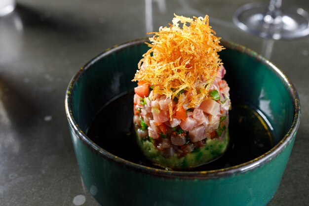 Tuna tartare with tomato lemon onion chili and fresh herbs in a crockery