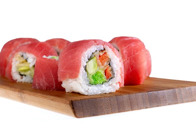 Tuna with tempura vegetables Set of rolls laid out on a bamboo pad white background Gourmet