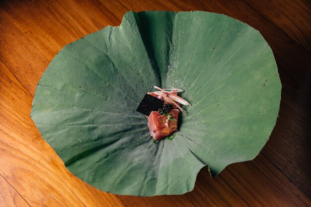 Tuna with yuzu-miso topping with black caviar and avocado served in lotus leaf