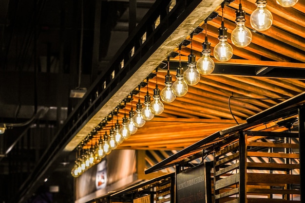 Tungsten circle lamp light on the row, stick on the wood kiosk ceiling.